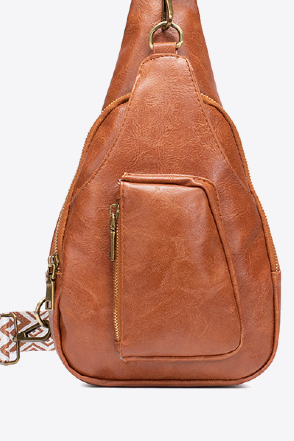 Side view of All The Feels PU leather sling bag in cognac brown with adjustable strap and zip pocket detail.