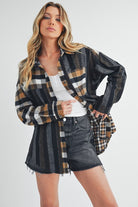 Woman wearing Aem+Co curved hem plaid button-up shirt with shorts, showcasing a trendy fall outfit.