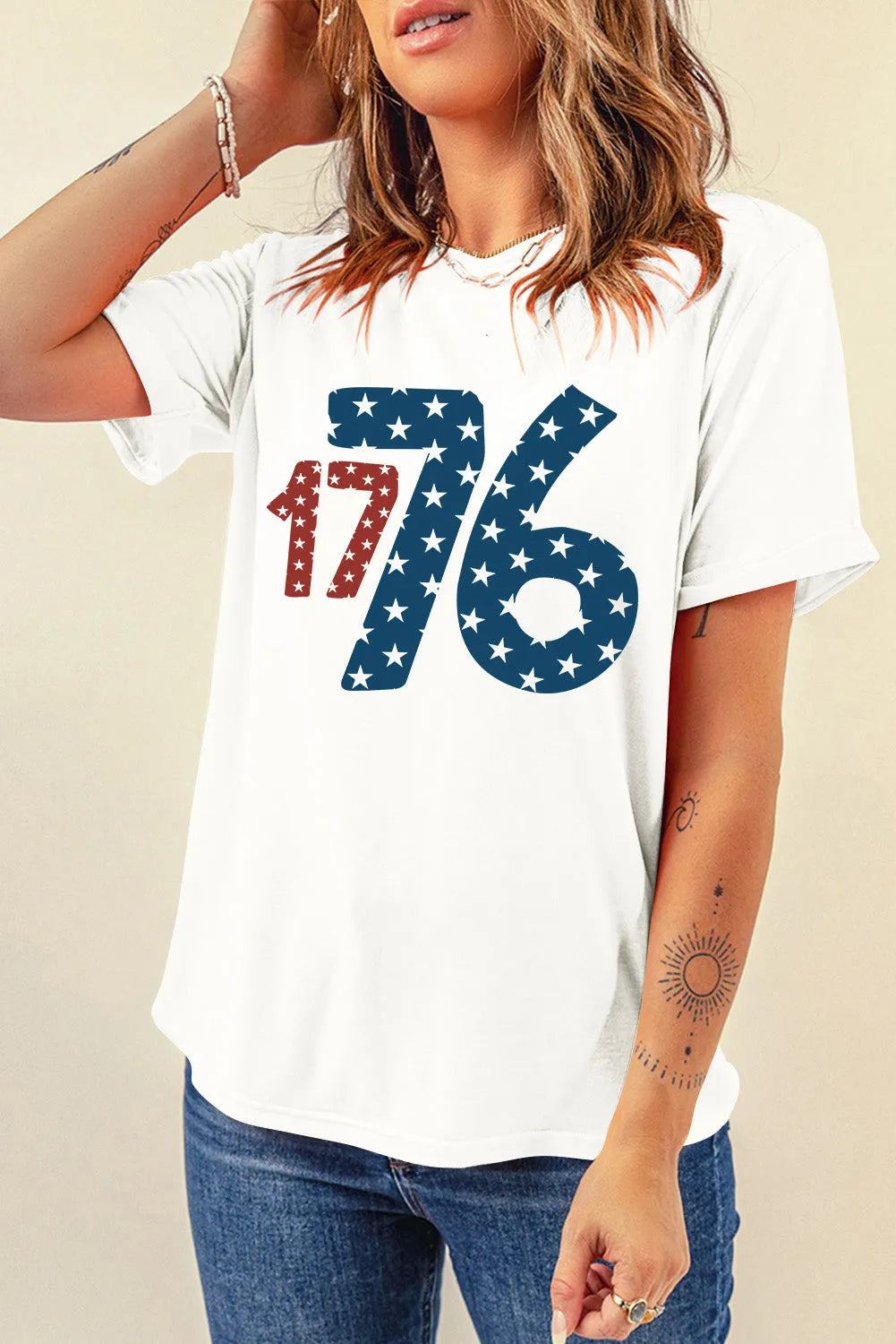 Woman wearing a 1776 round neck short sleeve T-shirt with star-themed design on a white background.