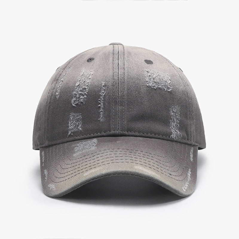 Adjustable cotton baseball hat in grey with distressed details, ideal for casual wear or outdoor activities.