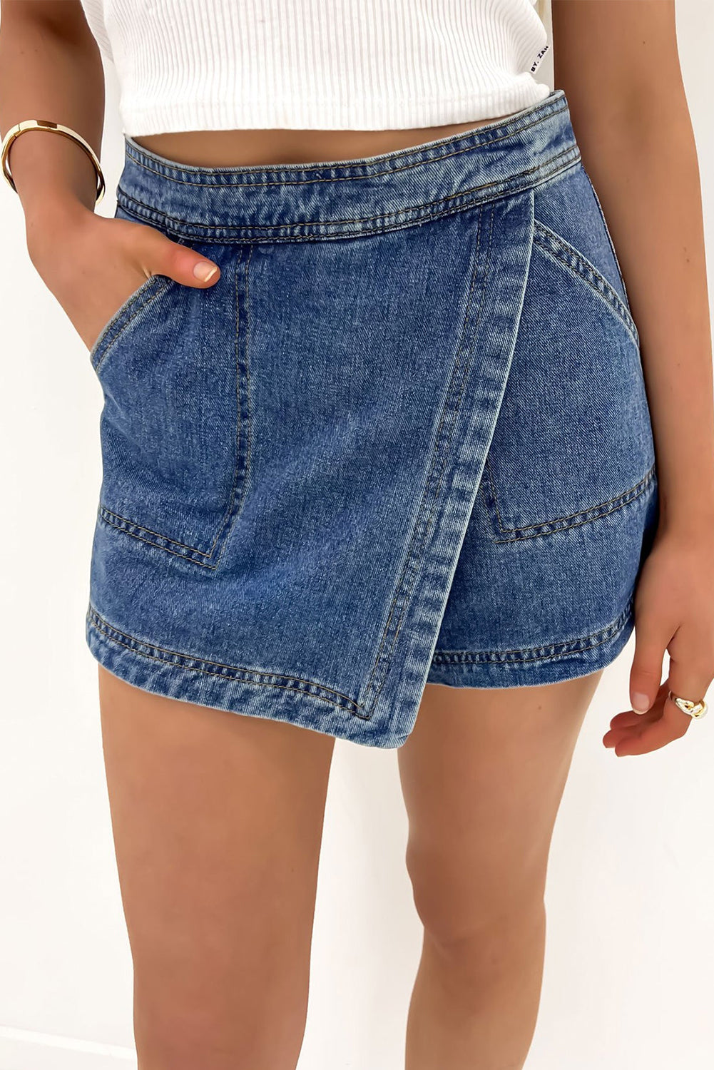 Ashleigh Blue Faux-Wrapped Mini Denim Skort for women from 6i6.com, a trendy and versatile summer piece.