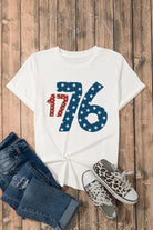 1776 round neck short sleeve T-shirt in white with red and blue star design, styled with denim shorts and patterned sneakers.